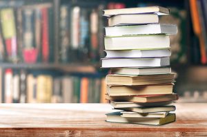 Photo of a stack of books in front of a wall of books