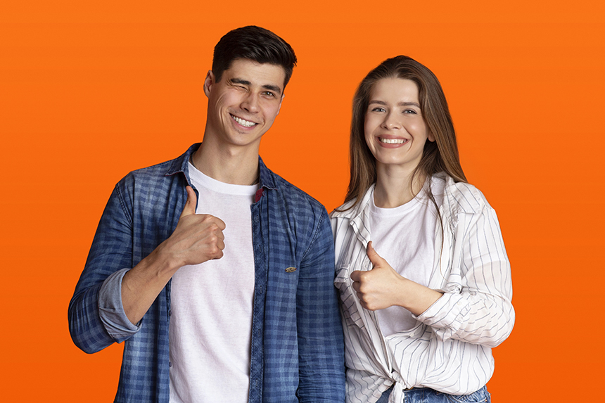 Male and female couple, casually dressed over an orange background